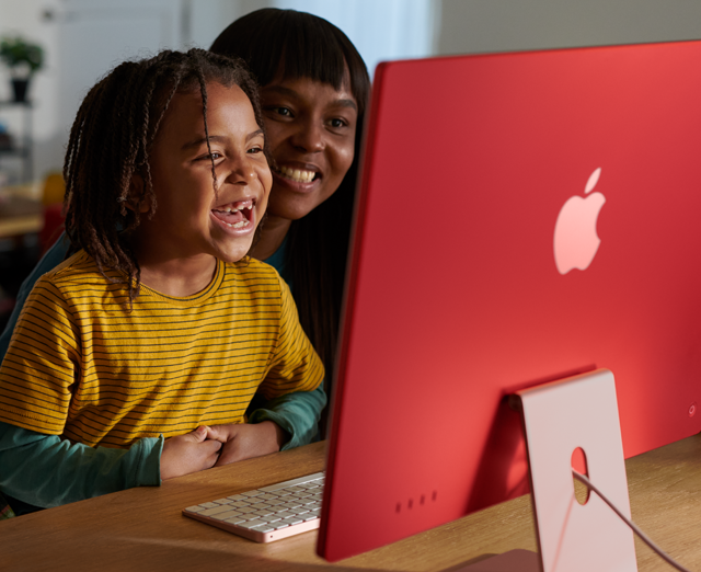 Una familia riéndose mientras mira un programa en el iMac.
